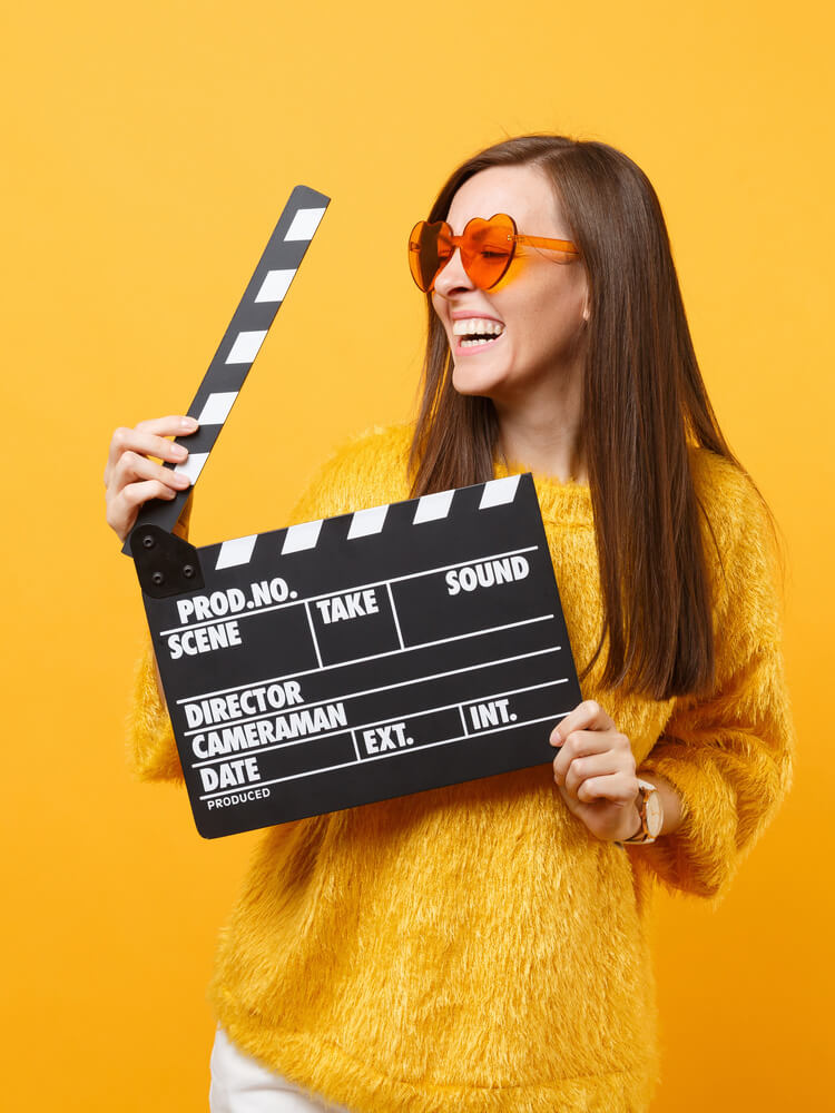 Kobieta trzymająca klapkę kinematograficzną | Agencja castingowa OBSADOWI