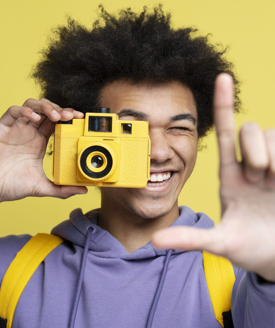 Uśmiechnięty afroamerykański fotograf robiący zdjęcie | Agencja castingowa OBSADOWI